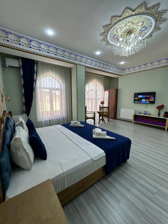 a bedroom with a large bed and a chandelier at Zarhal boutique Premium in Bukhara