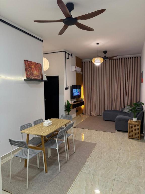 a living room with a table and a ceiling fan at Pool View - H&A Signature Klebang in Malacca