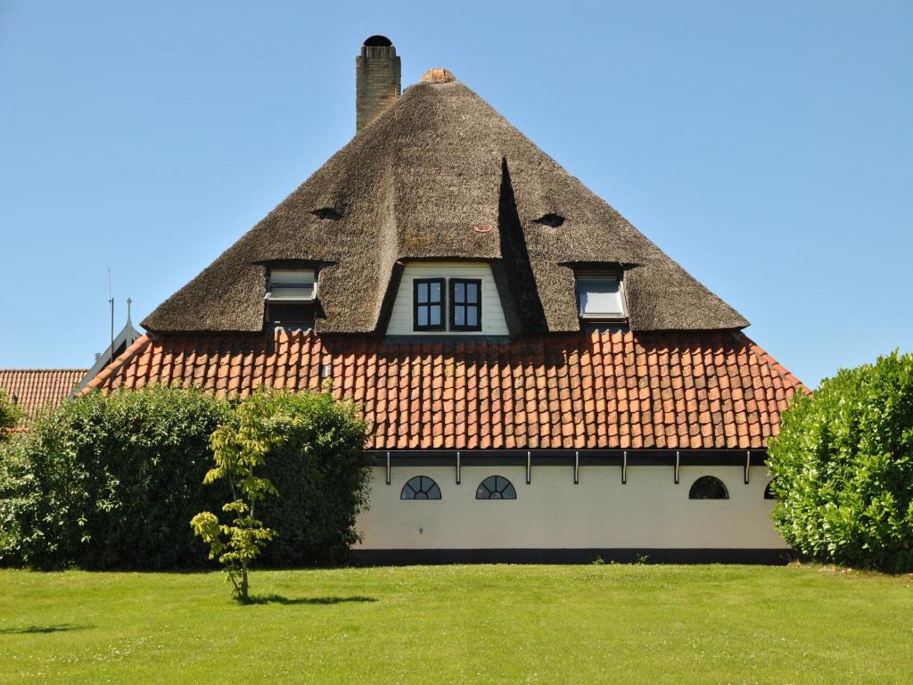 a thatch roofed house with a thatched roof at Lovely Holiday Home in Texel near Sea in Oost