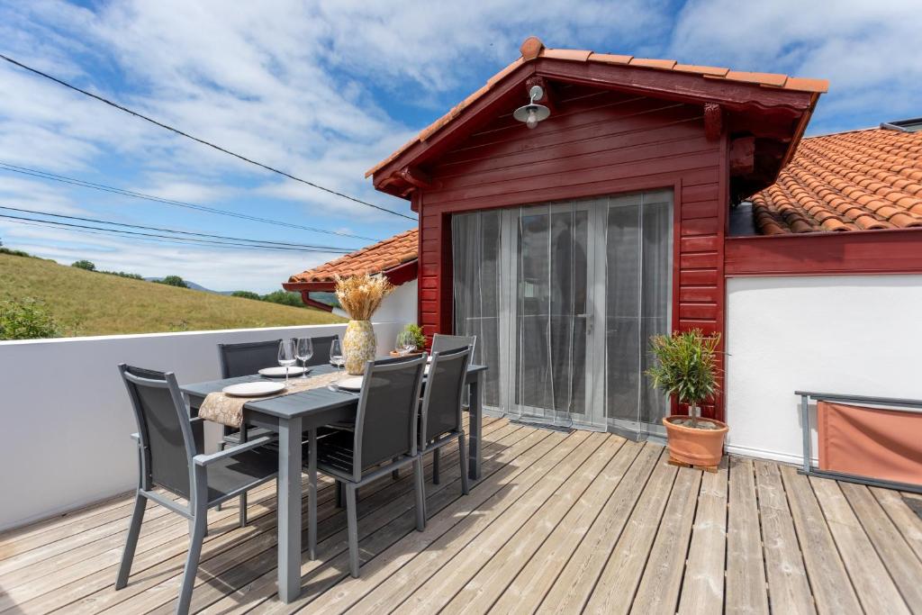 a patio with a table and chairs on a deck at Gite Goxa Leku in Ossès