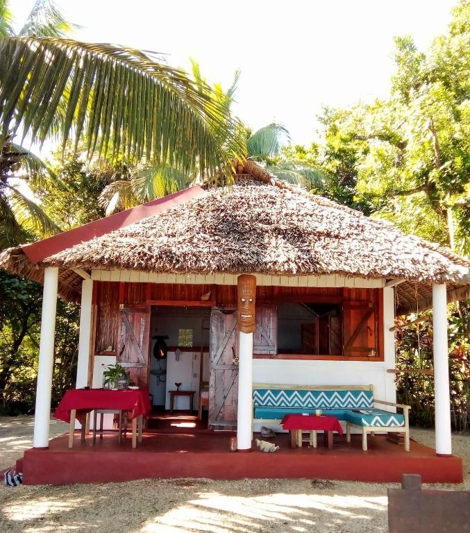 a small house with a thatched roof at Bungalow Ambanivolo in Sainte Marie