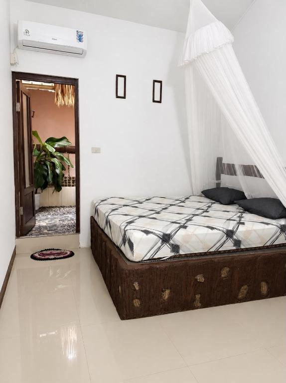 a bedroom with a bed with a mosquito net at Jungle life guesthouse Trekking & Transport Book with us in Bukit Lawang