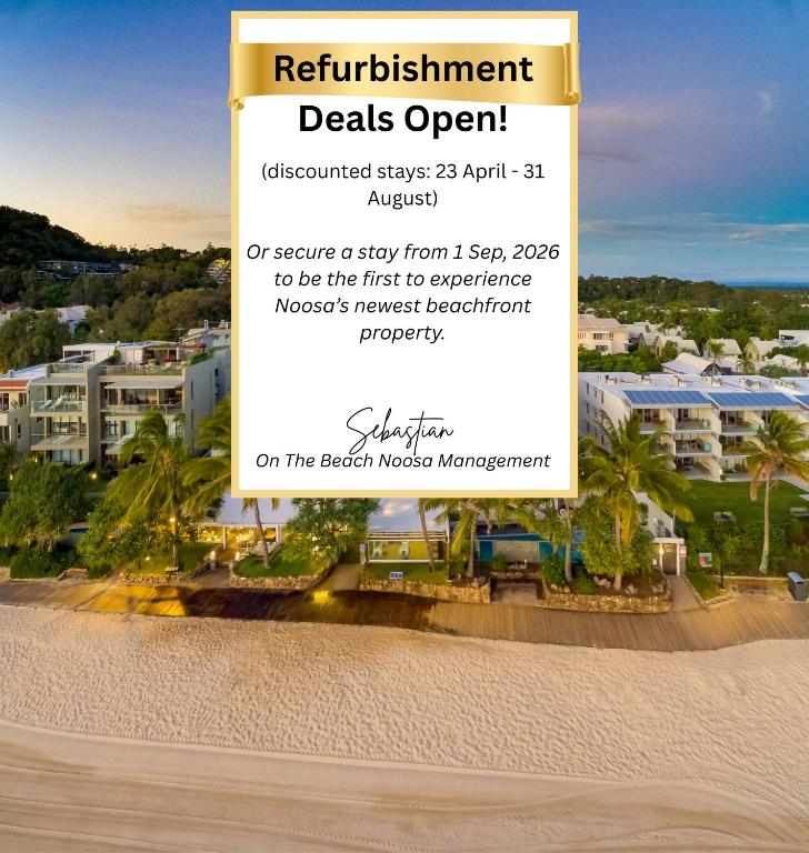 a sign for a hotel on the beach near the sand at On The Beach Noosa Resort in Noosa Heads