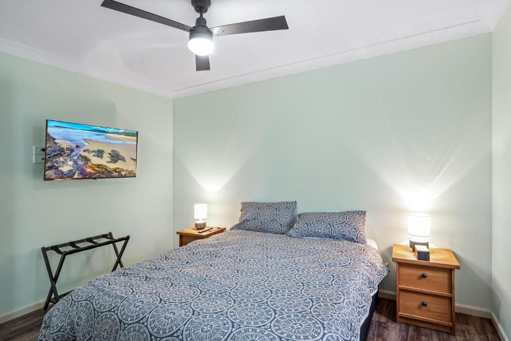 a bedroom with a bed and a ceiling fan at Tranquility Place in Evans Head