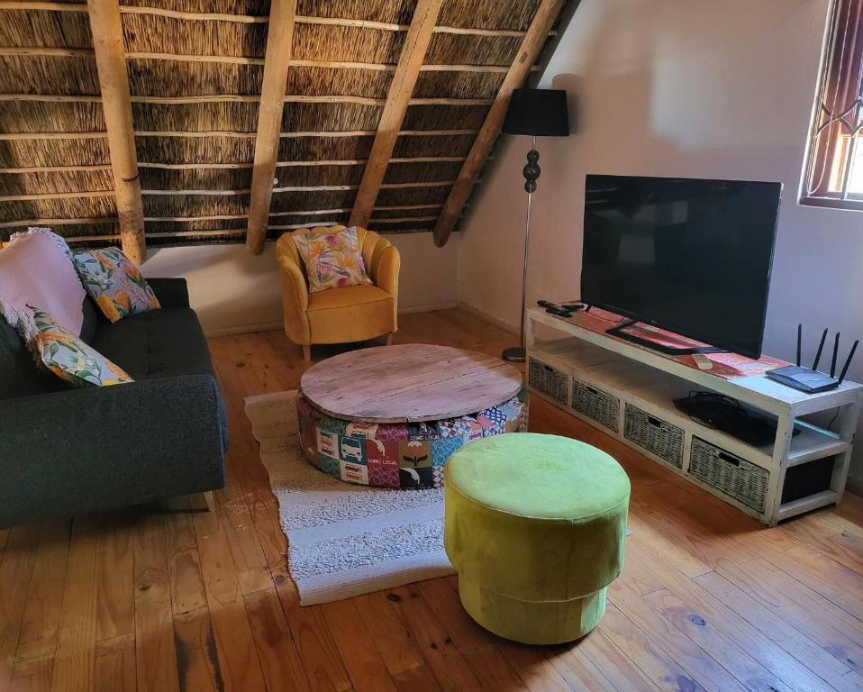 a living room with a couch and a tv at Unpretentious peaceful Cottage in Clanwilliam