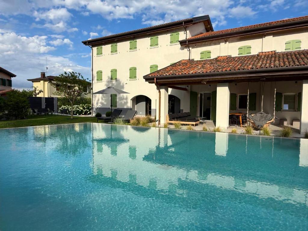 a swimming pool in front of a house at Jesolo Luxury Suites in Jesolo