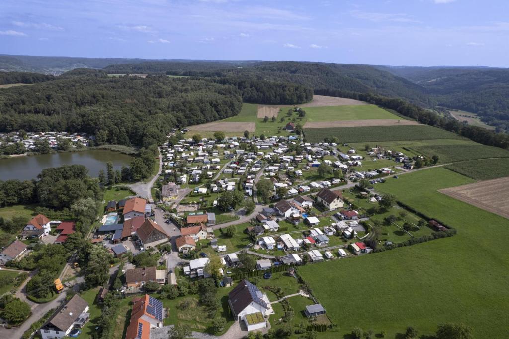 an aerial view of a village with a river and houses at Camping Seewiese in Pfedelbach