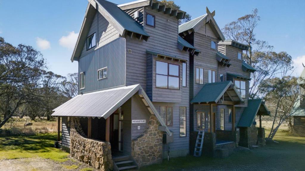 a large wooden house with a roof at Humffray 3 in Dinner Plain