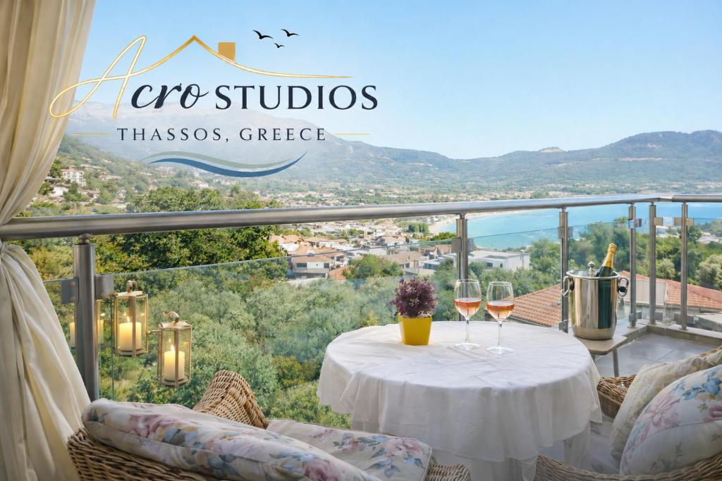 a table with two glasses of wine on a balcony at Acro Studios in Skala Potamias