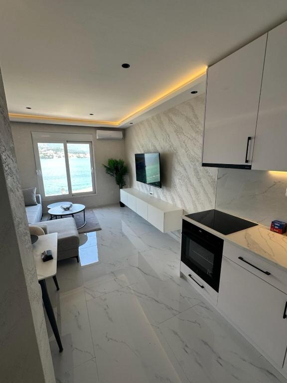 a kitchen with a living room with a couch and a tv at Bellanti2 in Igalo