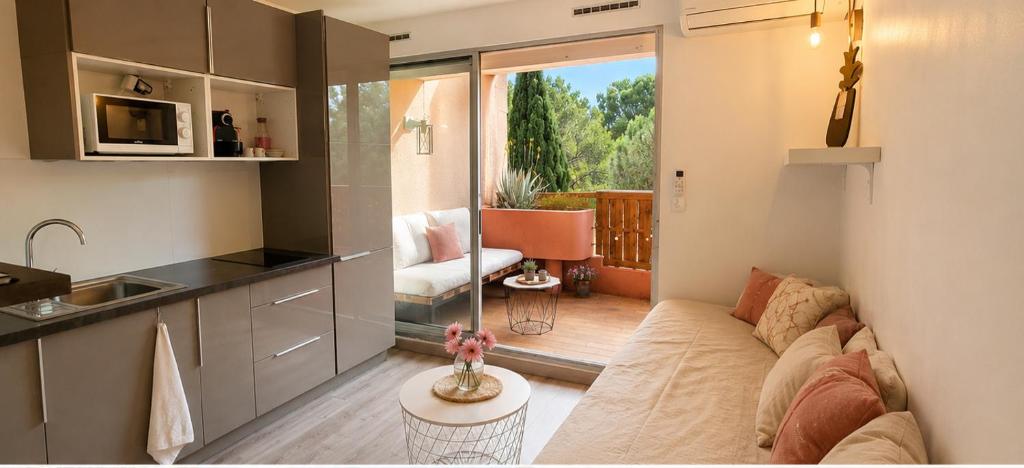 a living room with a couch and a kitchen at Studio Bord de Mer Résidence - Les Sablettes in La Seyne-sur-Mer