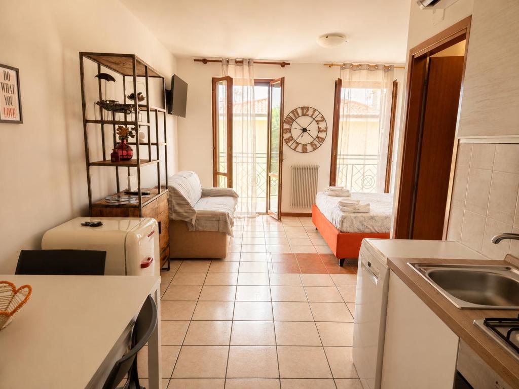 a kitchen with a sink and a living room at BeaMare - Monolocale - Massimo tre ospiti con posto spiaggia - Studio Apartment - Max 3 people with 1 private umbrella and two SunBeds at the private beach of Eraclea Mare in Eraclea Mare