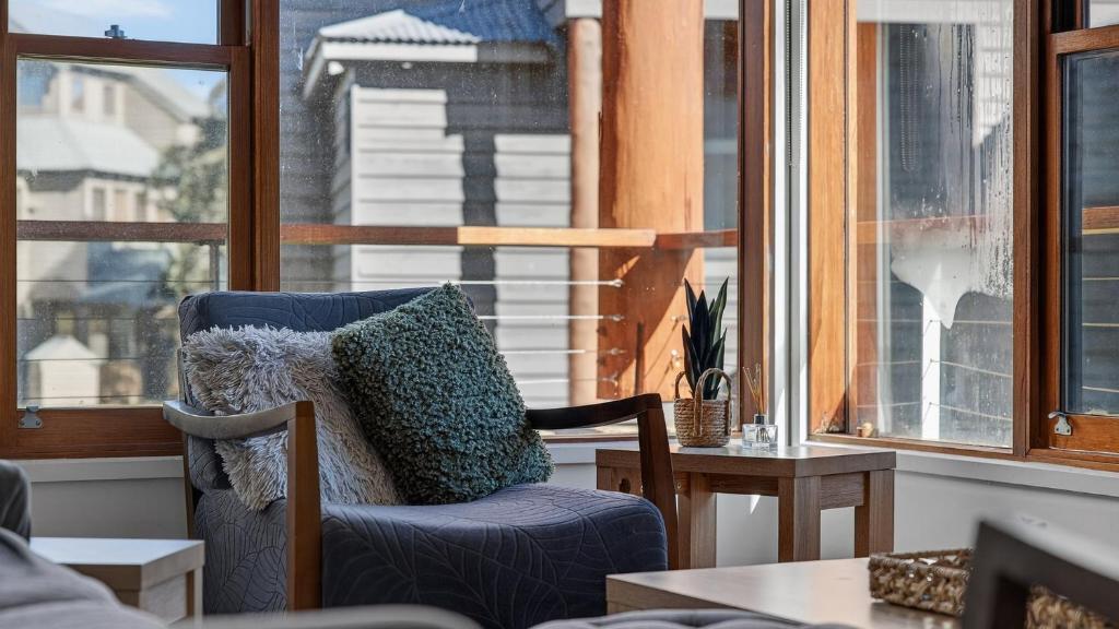 a blue chair sitting on a porch with a window at Triggerplant 2 in Dinner Plain