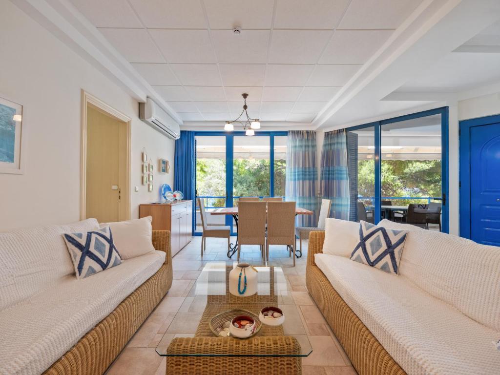 a living room with two couches and a table at Neptune Suite Sounio in Sounio