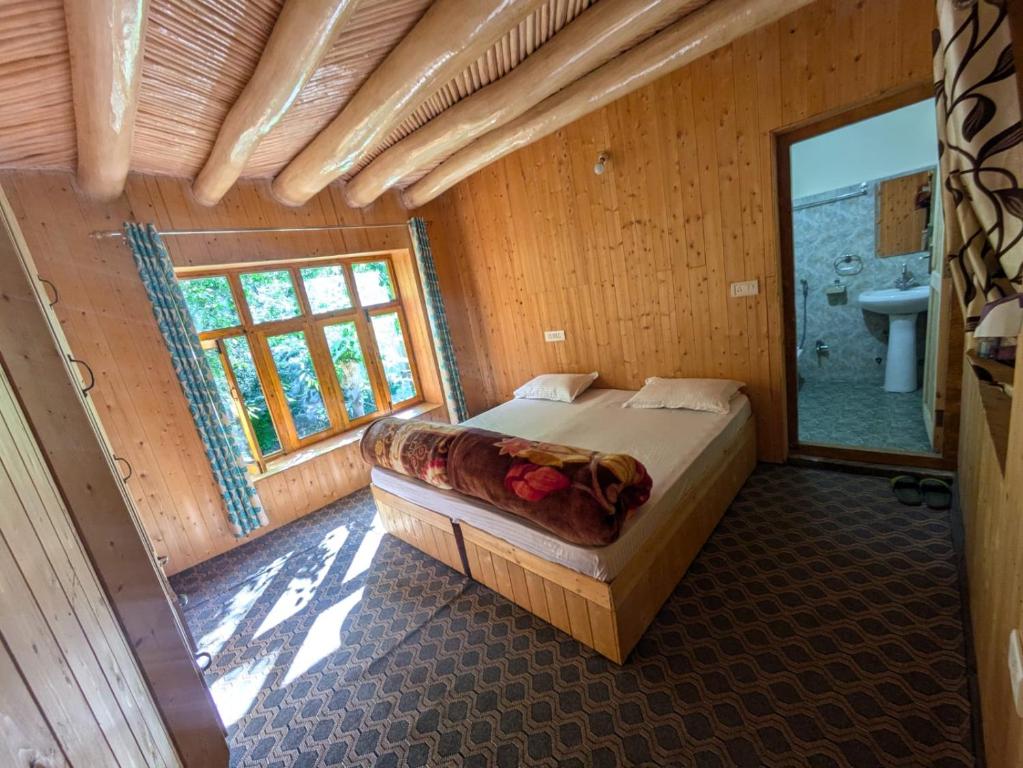 a bedroom with a bed in a wooden room at Turtuk Stream Side Home Stay in Turtuk
