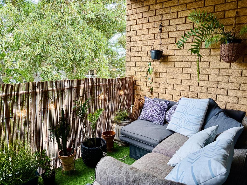 a couch sitting on the side of a patio at Cozy Bondi ROOM - Beach life and Local Host! Free Parking in Sydney
