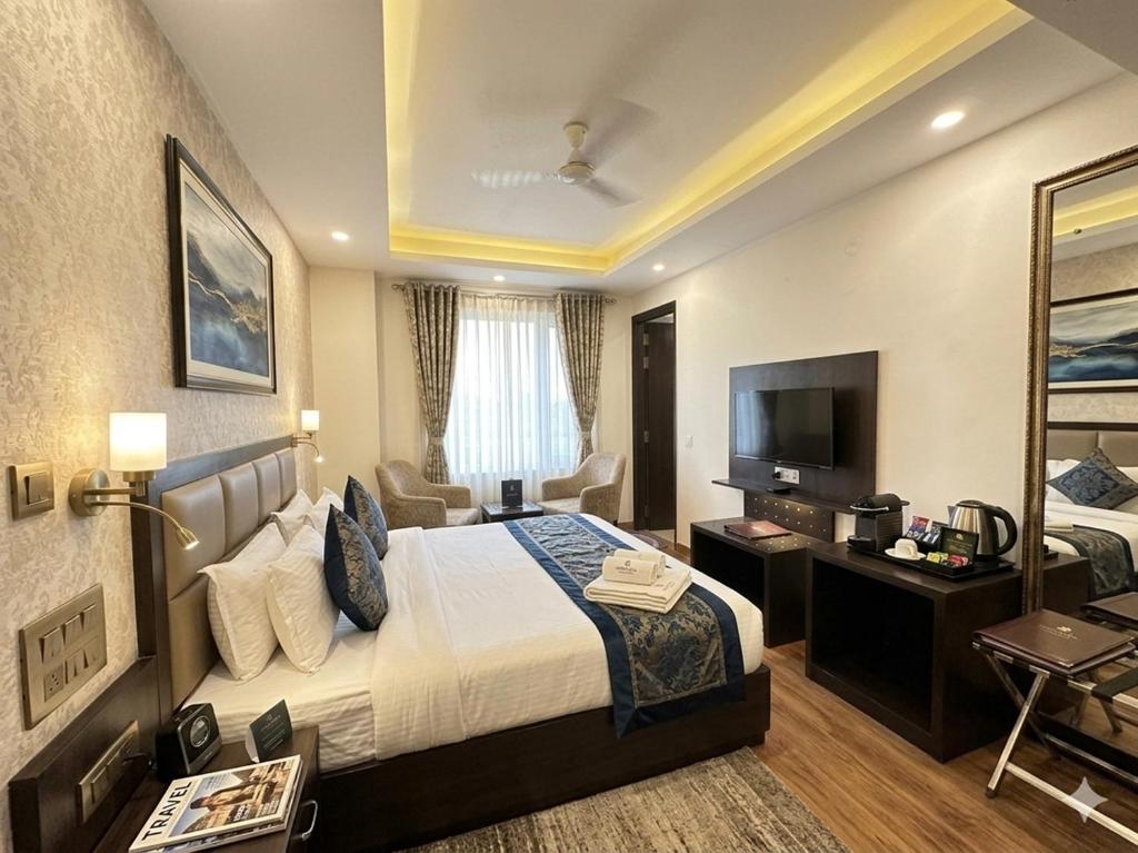 a hotel room with a bed and a television at Hotel Rajpath Residency 2 Min Walk From Kaushambhi Metro Station in Ghaziabad