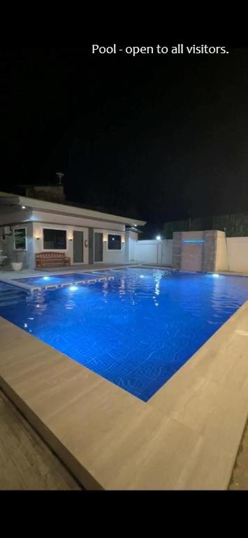 a large swimming pool with blue water at night at T'zam Villa in Dipolog