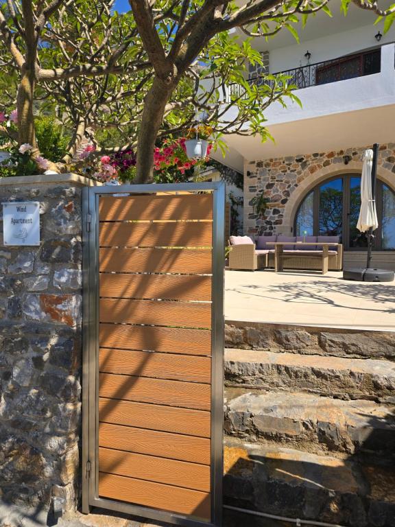 a wooden gate in front of a stone wall at Wind Apartment in Agia Roumeli in Agia Roumeli