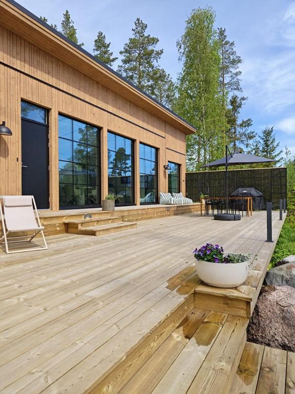 a large wooden deck in front of a building at New Seaside Villa with Beach Sauna and Panoramic Views in Porvoo