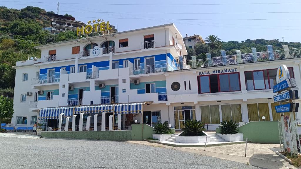 ein großes weißes Gebäude mit einem Schild darauf in der Unterkunft Hotel La Carruba in Cetraro