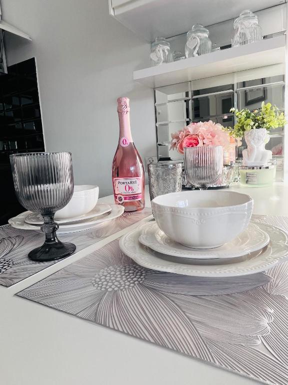 a table with plates and a bottle of wine at Apartament Borys in Malbork