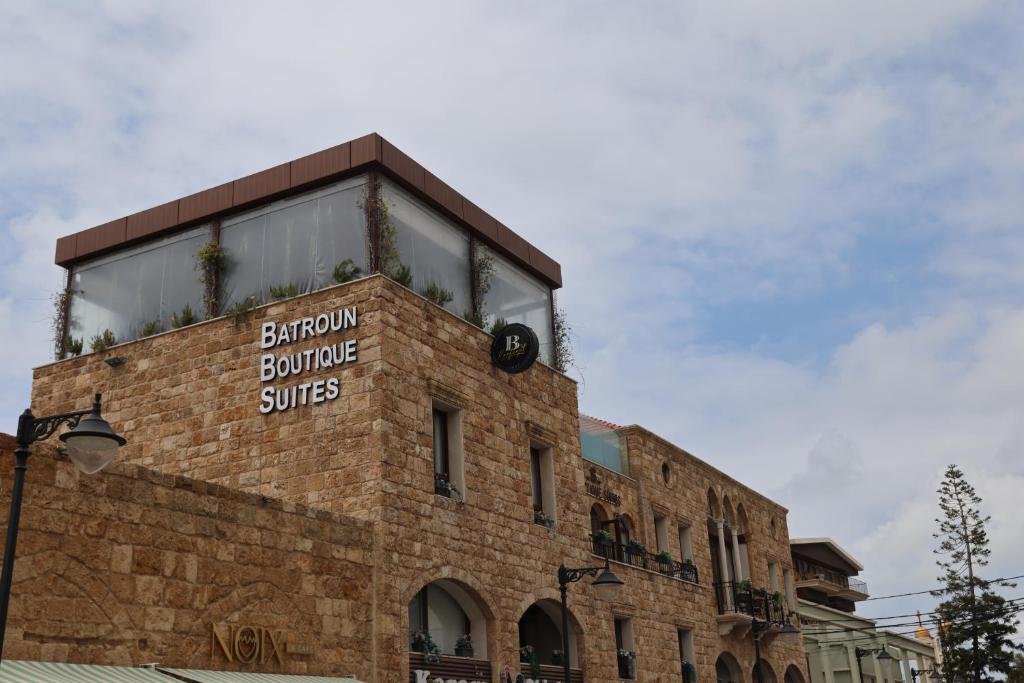 a brick building with a sign on the side of it at Batroun boutique suites in Batroûn