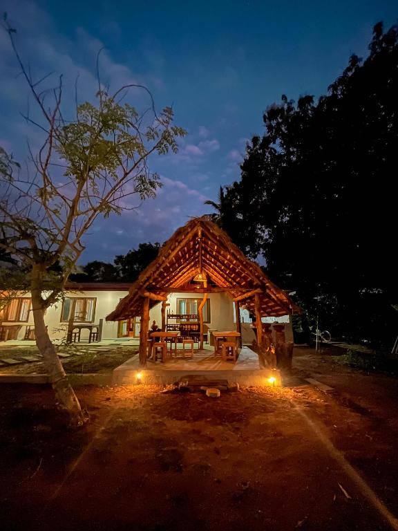 a house with a wooden roof and a patio at Mahagedara Villa Wilpattu in Nochchiyagama