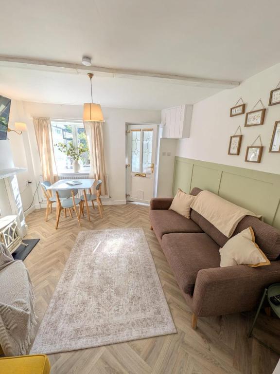 a living room with a couch and a table at Holly Cottage in Edwinstowe