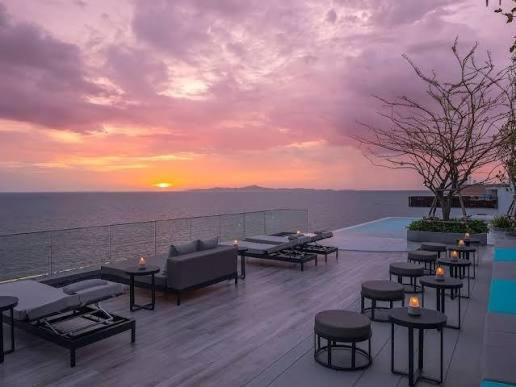 a deck with tables and chairs and a sunset at Navy black in Chom Bung