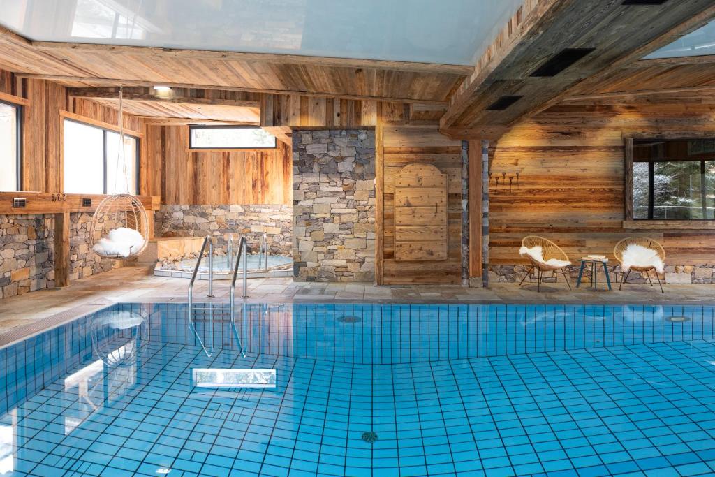 ein großes Schwimmbecken in einem Holzgebäude mit in der Unterkunft Les Cornettes in La Chapelle-dʼAbondance