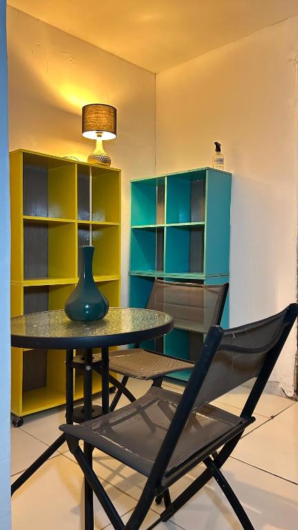 a table with a vase and a chair in a room at Fenomenall Kitnet in Campina Grande