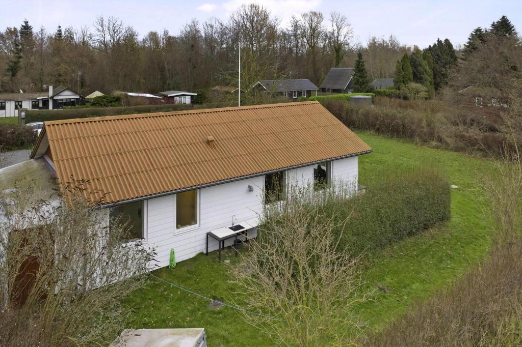 ein kleines weißes Haus mit braunem Dach in der Unterkunft Schönes Neu Renoviertes Sommerhaus Am Meer in Frørup