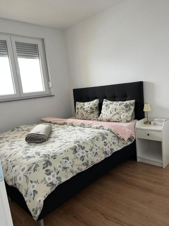 a bedroom with a bed with a black headboard at Apartman M&M in Teslić