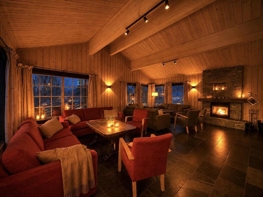 a living room with a couch and a fireplace at Spacious cabin in Hemsedal, 8 bedrooms and sauna in Hemsedal