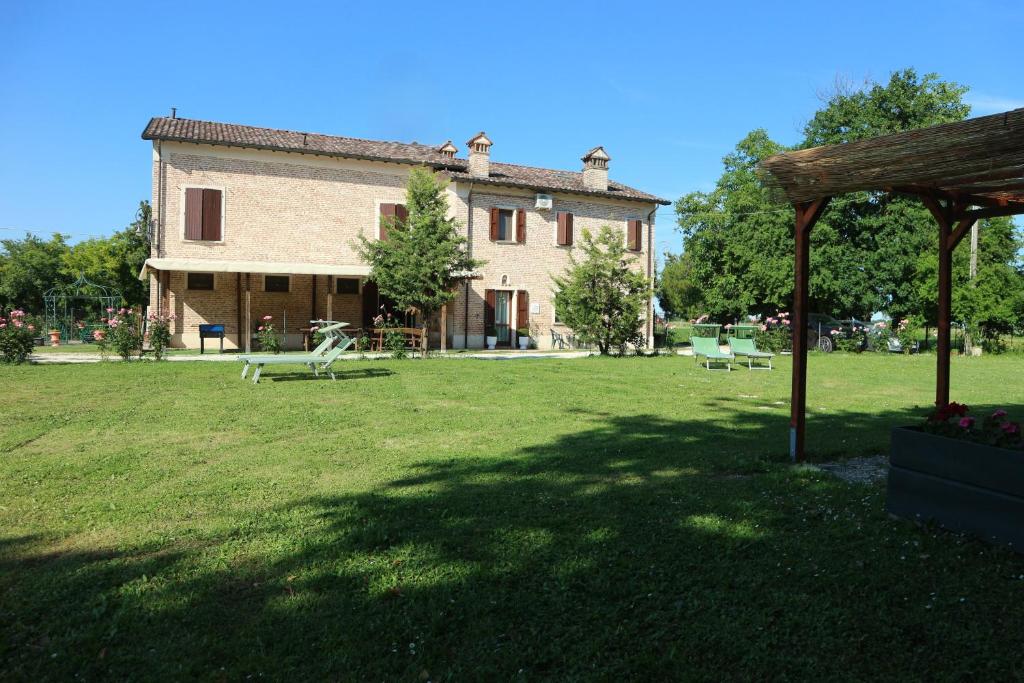 a large building in a field with a grass yard at Ca' Bianca in Lugo