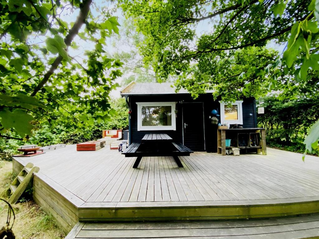 a small black tiny house on a wooden deck at Charming House With Big Private Terrace in Allinge