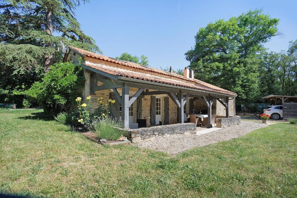 a small stone house in a grassy field at Gîte Le Cèdre, sans vis-à-vis in Limeyrat