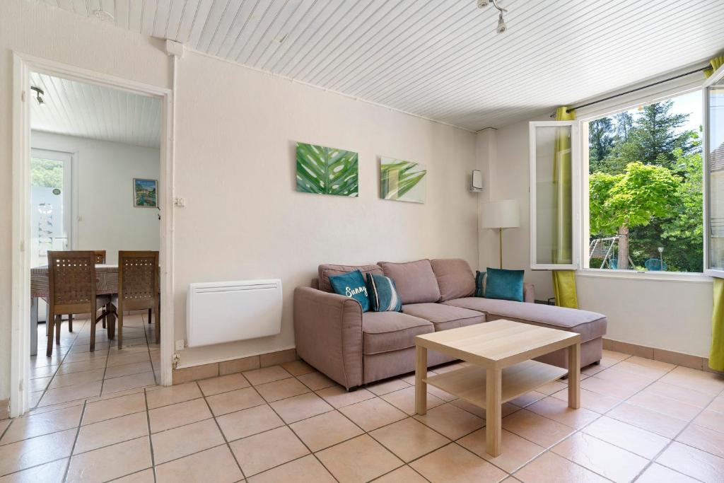 a living room with a couch and a table at La Mailleraie - L'etang in Valojoulx