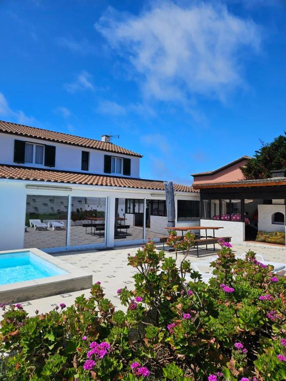 a villa with a swimming pool and a house at Casa da Uva-Mosteiros Vineyards House-Heated swimming-pool in Mosteiros