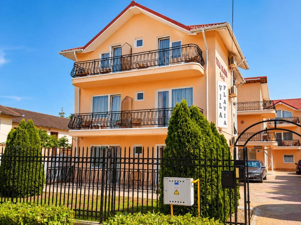 a building with a fence in front of it at Vila Flavia in Costinesti