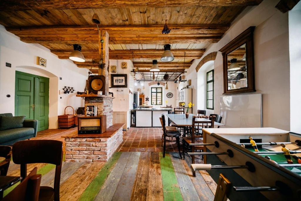 a living room with a pool table and a kitchen at Penzion Sborovna in Zbraslavice
