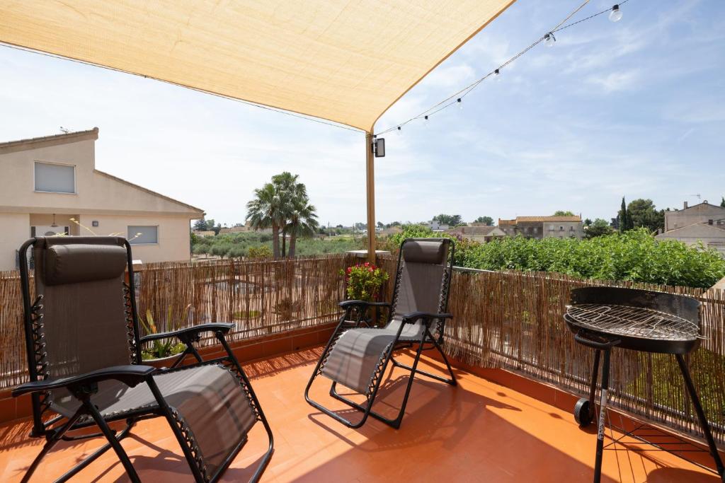 a patio with chairs and a table on a deck at Casa Gemina in Deltebre