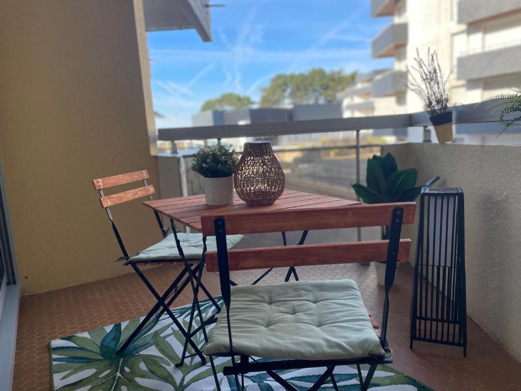a table with two chairs and a vase on a balcony at Le Studio in Bénodet