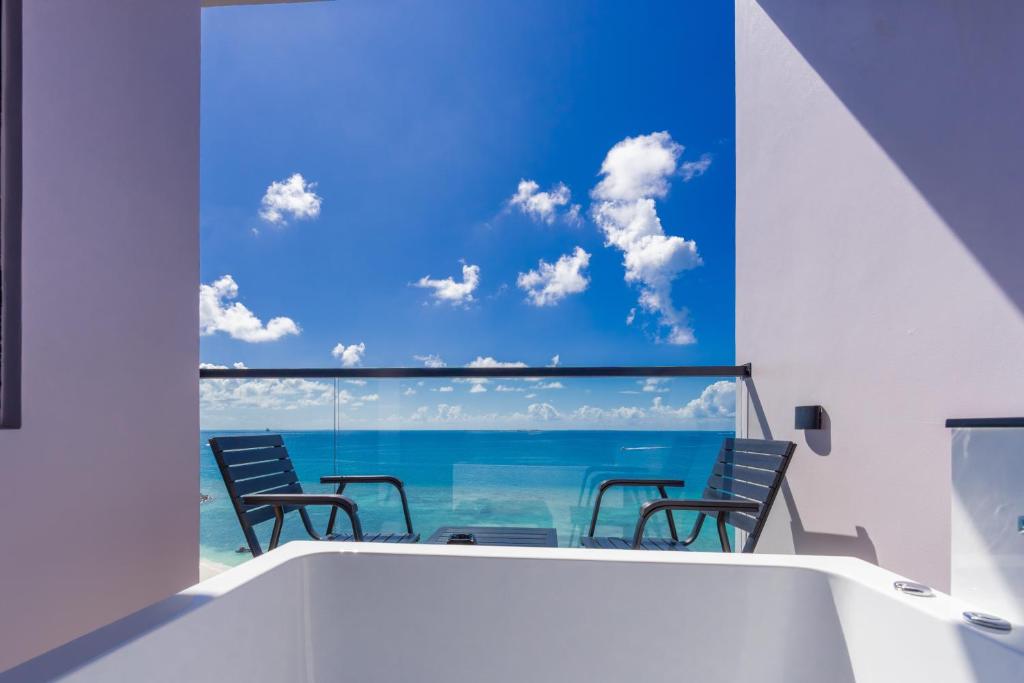 a balcony with chairs and a view of the ocean at Triton Exotica in Maafushi