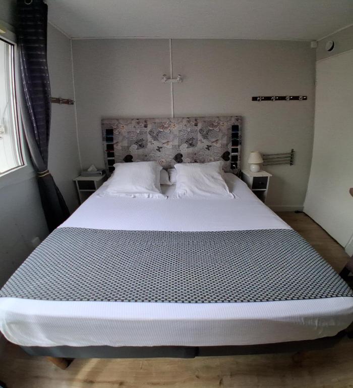 a bedroom with a large white bed in a room at Les Lavandins,Chambre climatisé, à 300 Tram L5, PARKING et WIFI gratuit in Montpellier