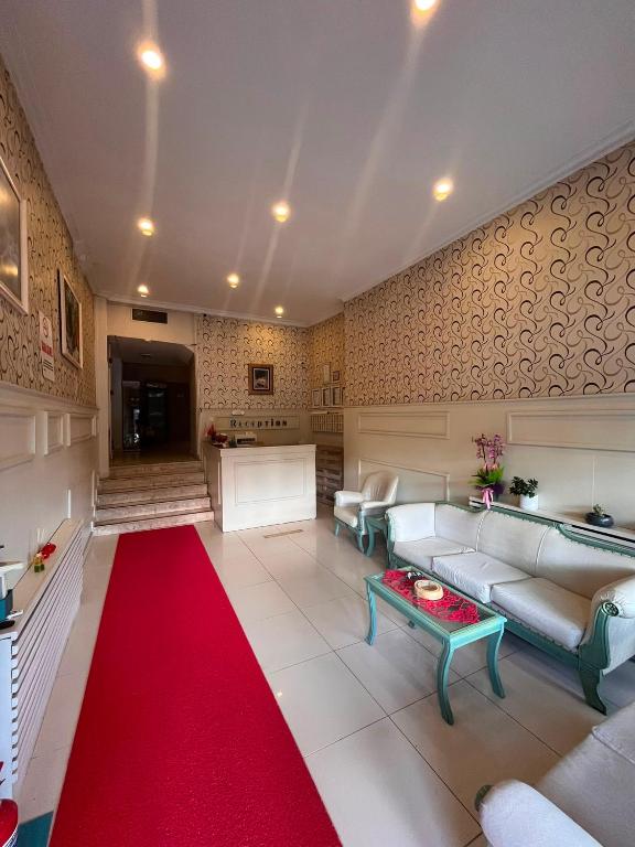 a living room with a red carpet and a red rug at Kiraz Otel in Lapseki