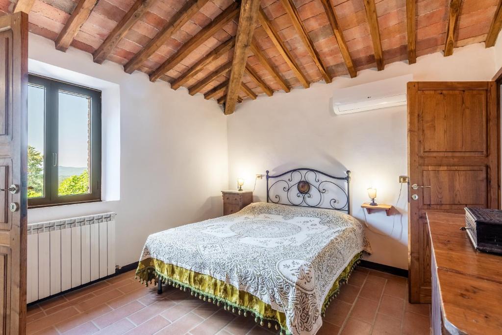 a bedroom with a bed and a window at Appartamento Brunello Murlo in Murlo