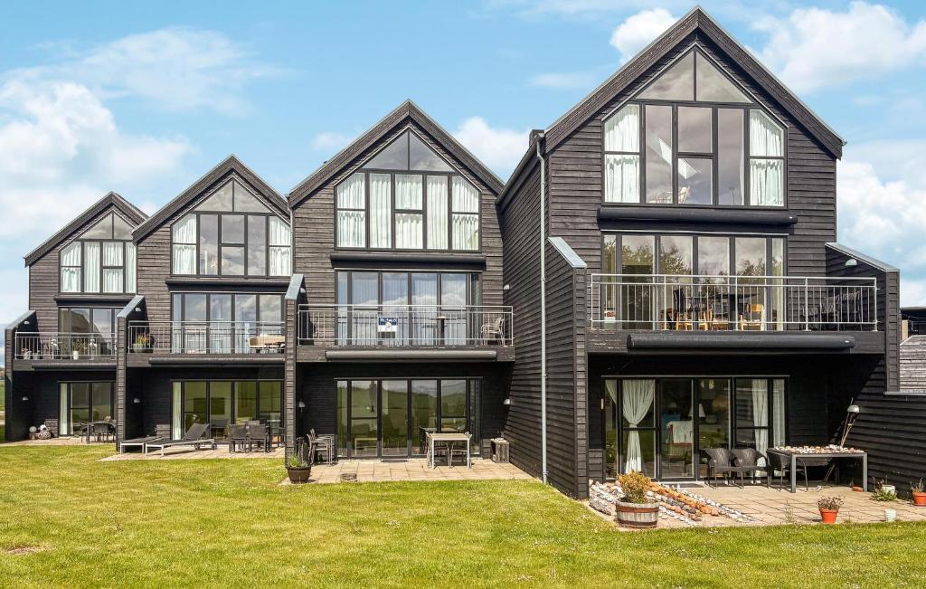 a large house with windows and a lawn at 2 Bedroom Nice Apartment In Samsø in Ballen