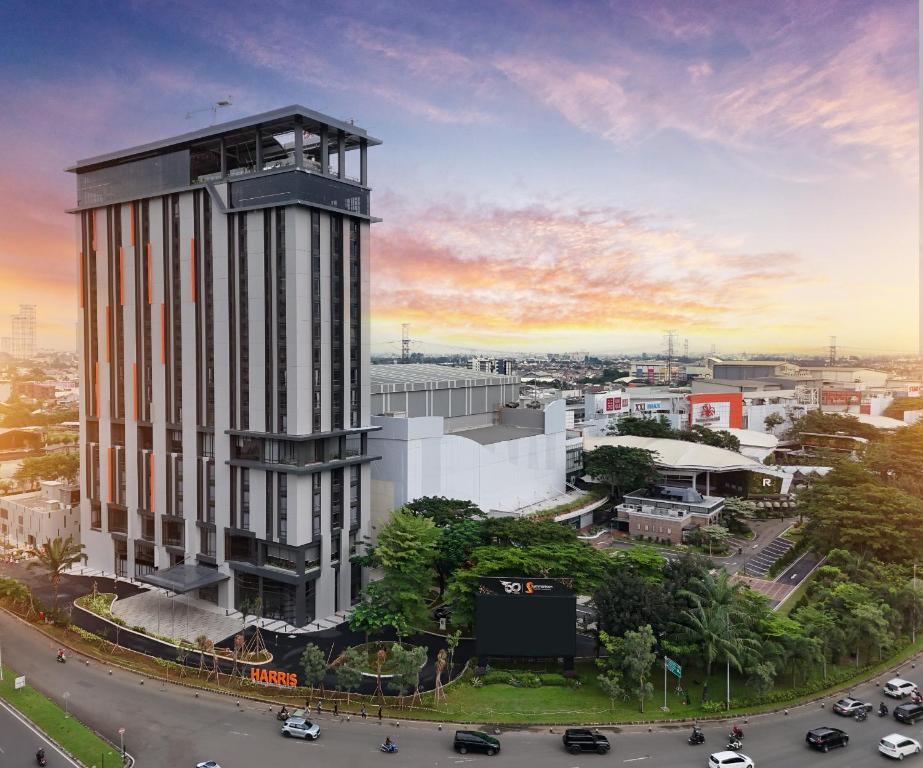 a tall building with a clock tower in a city at Harris Hotel & Convention Serpong in Tangerang